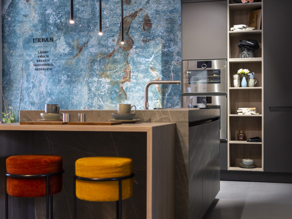 SieMatic-Küche mit Kochinsel und blauer Steinwand, Joe's Möbelboutique Projekt
