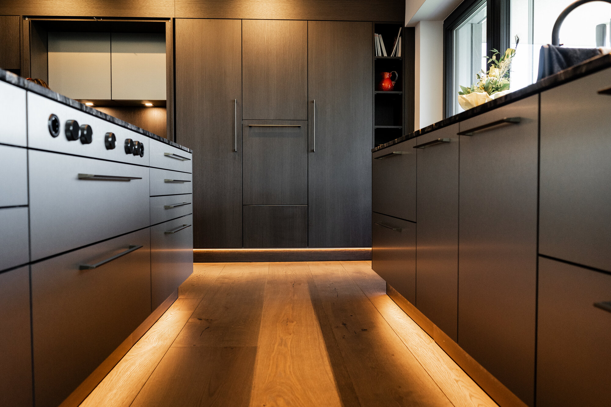 Dunkle Eichenküche mit indirekter LED-Beleuchtung am Eichenboden