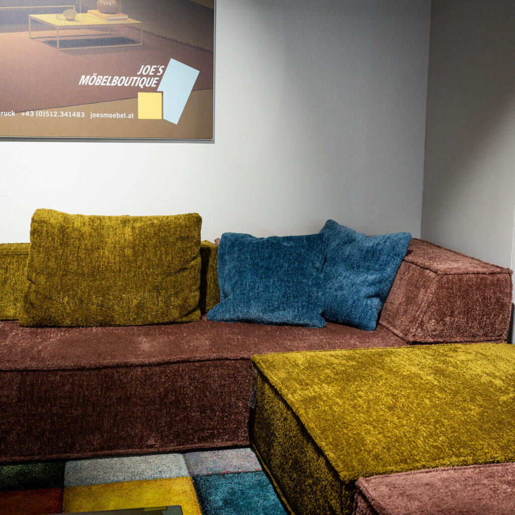 Modulsofa in Senfgelb und Altrosa in der Lounge-Ecke von Joe's Möbelboutique